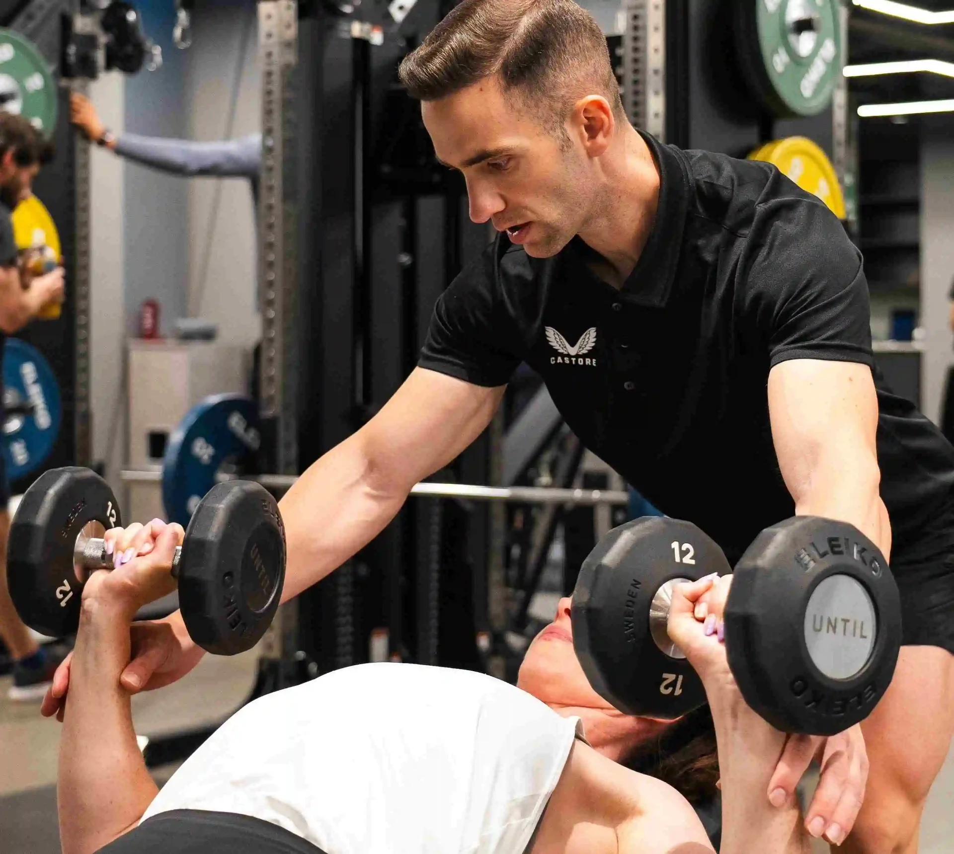 Maurizio Bua coaching a client during a dumbbell press
