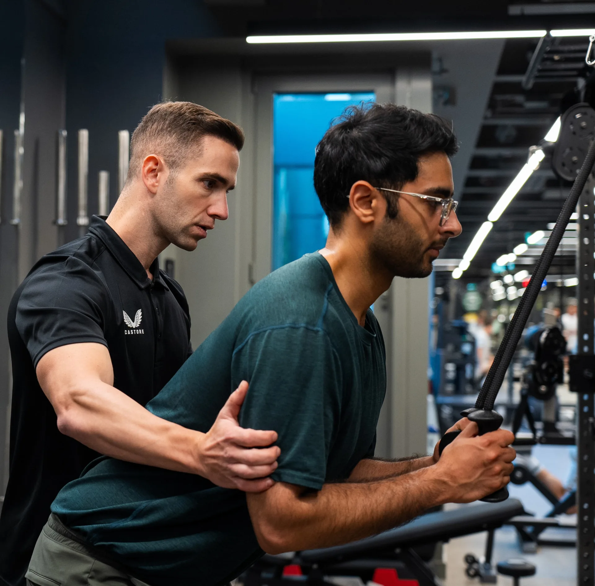 Maurizio coaching a client through a cable exercise
